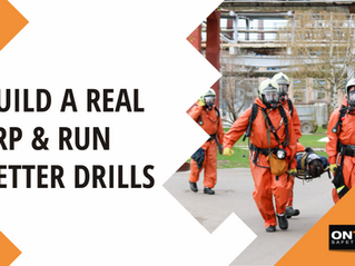 Emergency response team on a jobsite reviewing procedures with high-visibility PPE, first aid kits, and radios in hand, preparing for a simulated incident drill.
