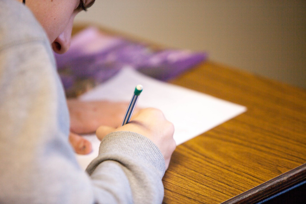 <img src="student.jpg" alt="student hold pencil and paper doing homework at a desk">