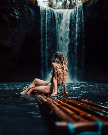 Young woman exploring a hidden waterfall in Bali surrounded by lush jungle