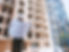 Construction worker holding architetural plans. infront of a building.