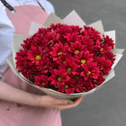 Florist holding a bouquet of red chrysanthemums