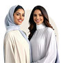Two smiling Middle Eastern women in modest light-toned attire.