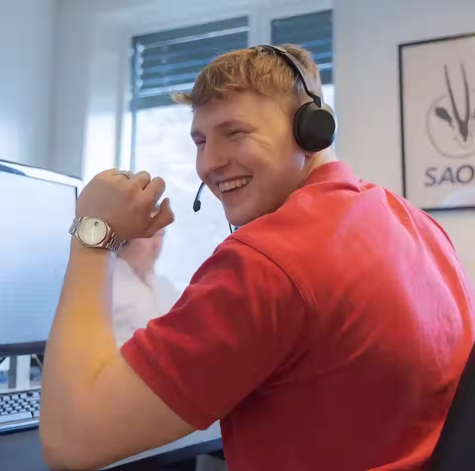 Mann som smiler i kontorlandskap