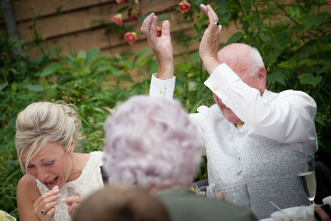 Bride and her father laughing at the top table during the speeches