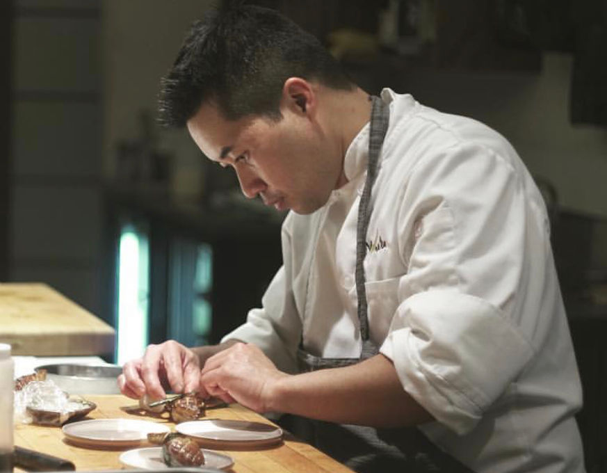 Chef Ramir carefully plating food in a professional kitchen