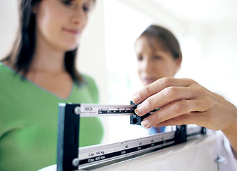Doctor adjusting balance on weighing sca