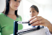 Doctor adjusting balance on weighing sca