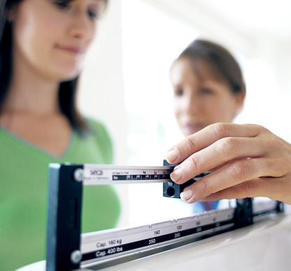 Doctor adjusting balance on weighing sca