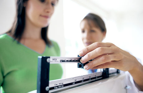 Doctor adjusting balance on weighing scale