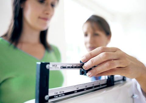 Doctor adjusting balance on weighing scale