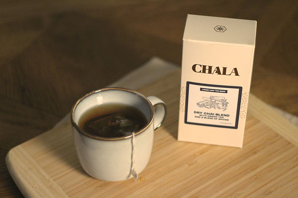 A box of chai with a cup and chai tea bag in it.