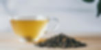 Brewed black tea in a glass mug withdraw, loose leaf tea in the foreground.
