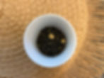 Loose Leaf Jasmine Flavoured Green Tea in a white cup on top of a brown mat.