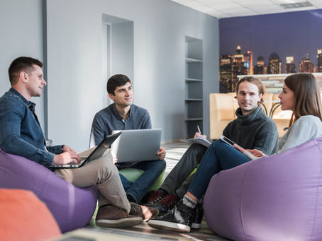 Fundadores de startup em reunião estratégica antes da abertura do CNPJ, discutindo aspectos jurídicos como Memorando de Entendimentos, responsabilidades iniciais e proteção da propriedade intelectual para evitar riscos na formalização da empresa.