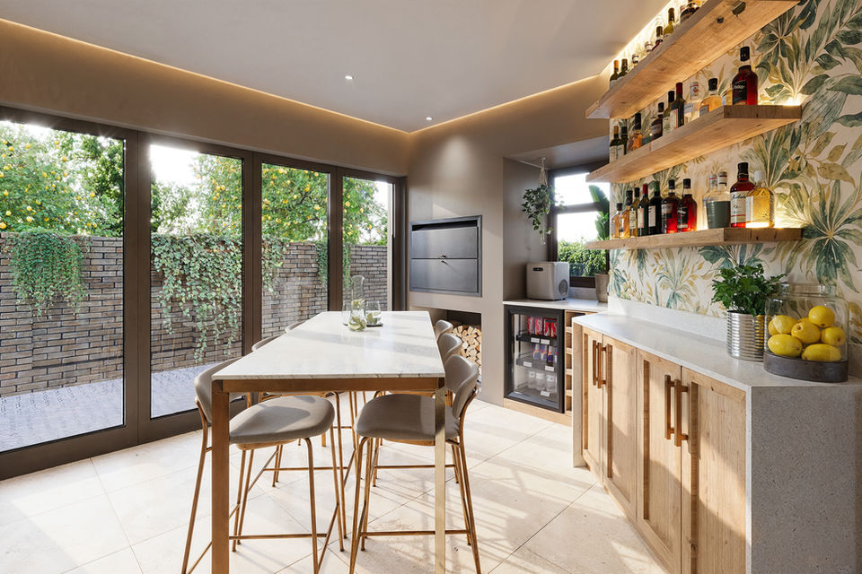 Luxury home bar with botanical wallpaper, marble countertop, wooden cabinets, floating shelves with lighting, and gold bar stools in Meyersdal Johannesburg designed by Arcvisa Studio