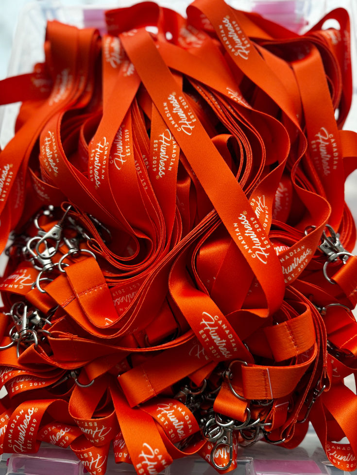 Canadian Huntress® blaze orange branded lanyard with metal clip for outdoor, field and everyday use.