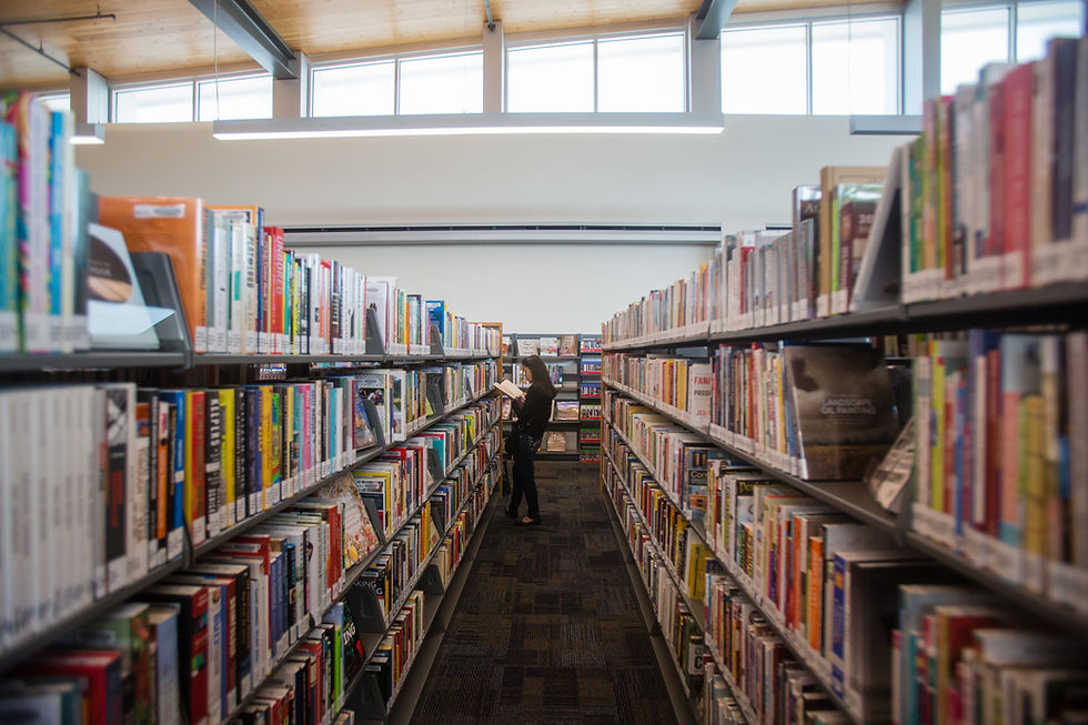 A woman browsing rows of books at the Boise Public Library.