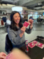 a woman smiling and holding up her winning bingo card.