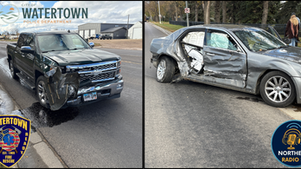 Two vehicles with collision damage on a street: a black truck and a silver car. Logos for Watertown Police and Fire Rescue visible.