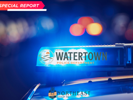 Police car with flashing blue lights, blurred city background. Text: Special Report, Watertown Police Department, Northeast Radio SD.