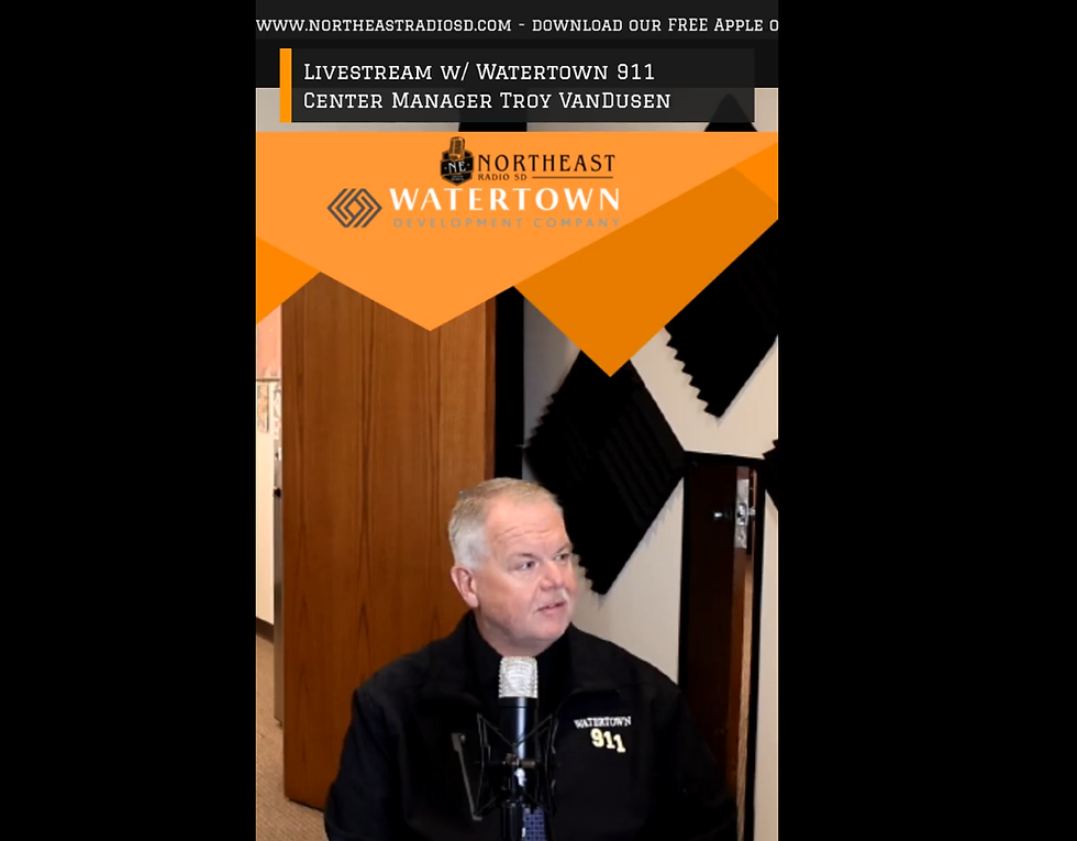 Man in a Watertown 911 shirt speaks into a microphone during a Northeast Radio SD livestream, with orange promo banners and event text.