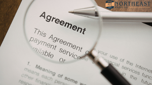 Magnifying glass and pen over an agreement document, with Northeast Radio SD logo in the top right.