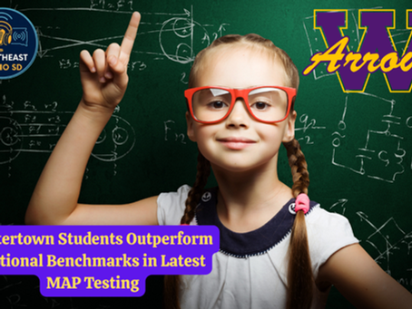 Girl with red glasses and pigtails raises finger in front of a chalkboard with equations. Text: Watertown students excel in MAP testing.