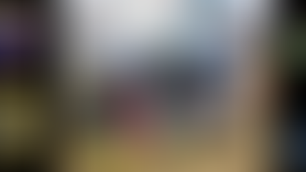 Crash scene with overturned car on grass, supported by stabilizers. Fire truck in background. Multiple agency logos on sides.