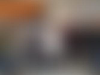 Seven people stand smiling in a room, wearing casual and business attire. Signs read "39th Annual Watertown Home Show" and "Northeast Radio SD."