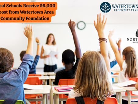 Students in a classroom raise hands, facing a teacher. Text: "Local Schools Receive $6,000 Boost from Watertown Area Community Foundation." Bright, engaged mood.