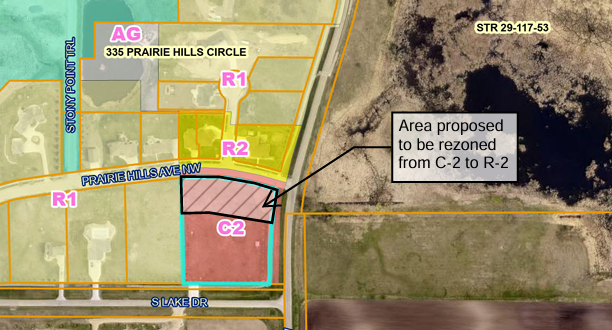Map showing rezoning proposal from C-2 to R-2 on Prairie Hills Ave NW and S Lake Dr. Color-coded zones and text annotations visible.