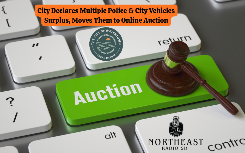 Green "Auction" key on keyboard with a gavel. Text: "City Declares Multiple Police & City Vehicles Surplus." Watertown, SD logo visible.