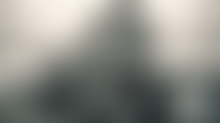 A propane truck travels on a snowy road with forests in the background. The tank is marked with "1075" and "PROPANE" signs. Gray skies above.