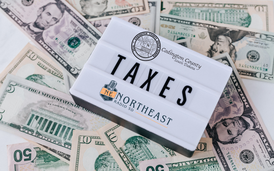 Lightbox sign reading TAXES over scattered US dollar bills, with Codington County South Dakota and Northeast Radio SD logos.