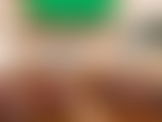 Crowd of children and adults raise hands at the "Beads on One String" event in Goss Opera House. Banner text promotes kindness event.