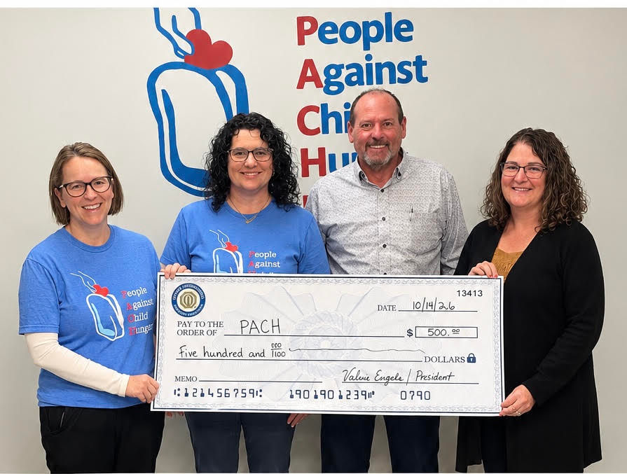 Four adults pose in front of a People Against Child Hunger wall logo, holding a giant $500 check for PACH and smiling.