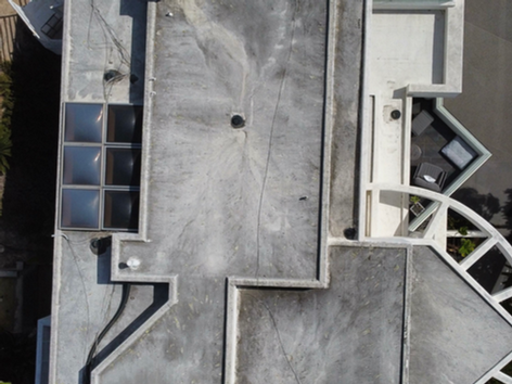 Drone photo of a dirty roof covered in debris and algae, before professional roof cleaning services.