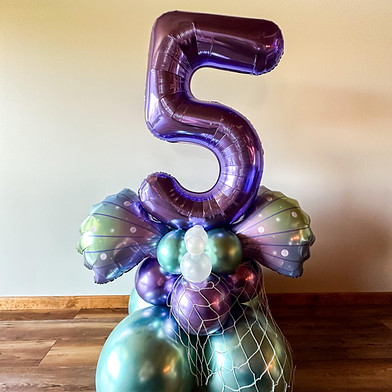 Purple 5 balloon on top of mermaid balloons