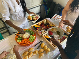 A delectable selection of food items, featuring mini smoked chicken salad sandwiches, charcuterie boards, a vibrant veggie tray, and an assortment of savory dips, enhancing the culinary experience at the Grace-filled Garden Party.