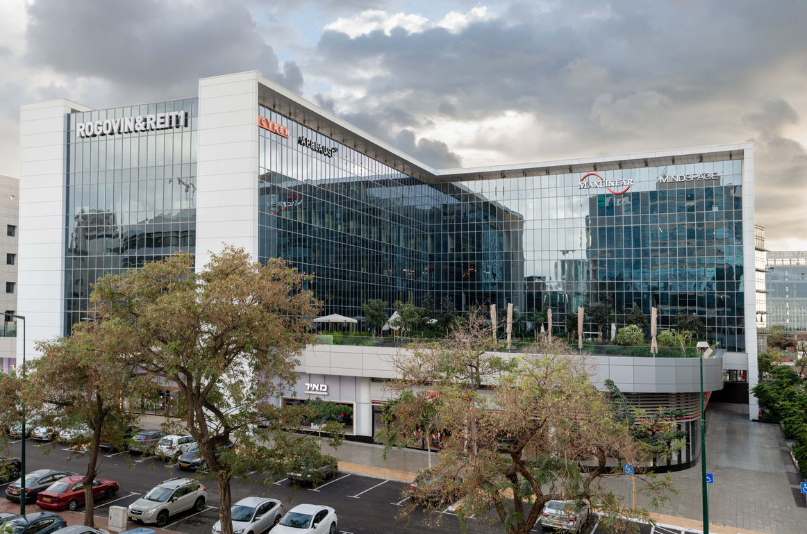 Modern office building exterior, featuring prominent company logos
