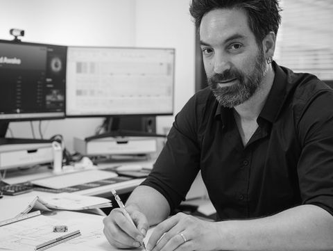 Architect sketching at desk, SoundHound app visible