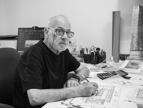 Architect at his desk reviewing blueprints