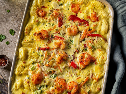 Ofen-Gnocchi mit Garnelen in cremiger Curry-Dattel-Soße in einer Auflaufform,