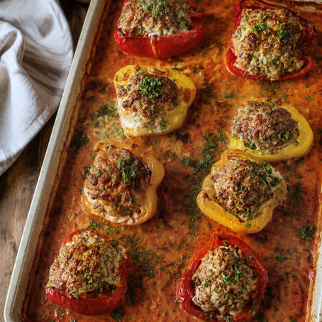 Überbackene gefüllte Paprika aus dem Ofen mit Hackfleisch, Reis und cremiger Tomatensoße im Ofenzauberer zubereitet und mit frischer Petersilie garniert.