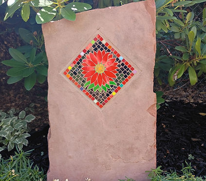 Monolith stone with a tile mosaic  red flower inlaid into the stone 