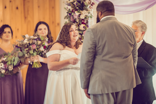 a bride reads her vows to her groom during the ceremony, stifling tears