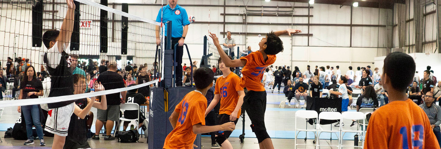 Players competing in a youth volleyball match.