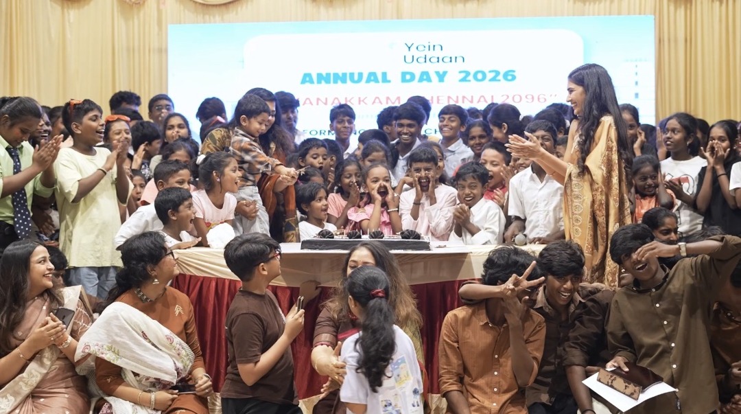 Children, families and the Yein Udaan team cheer around a cake at the Annual Day 2026 production in Chennai.