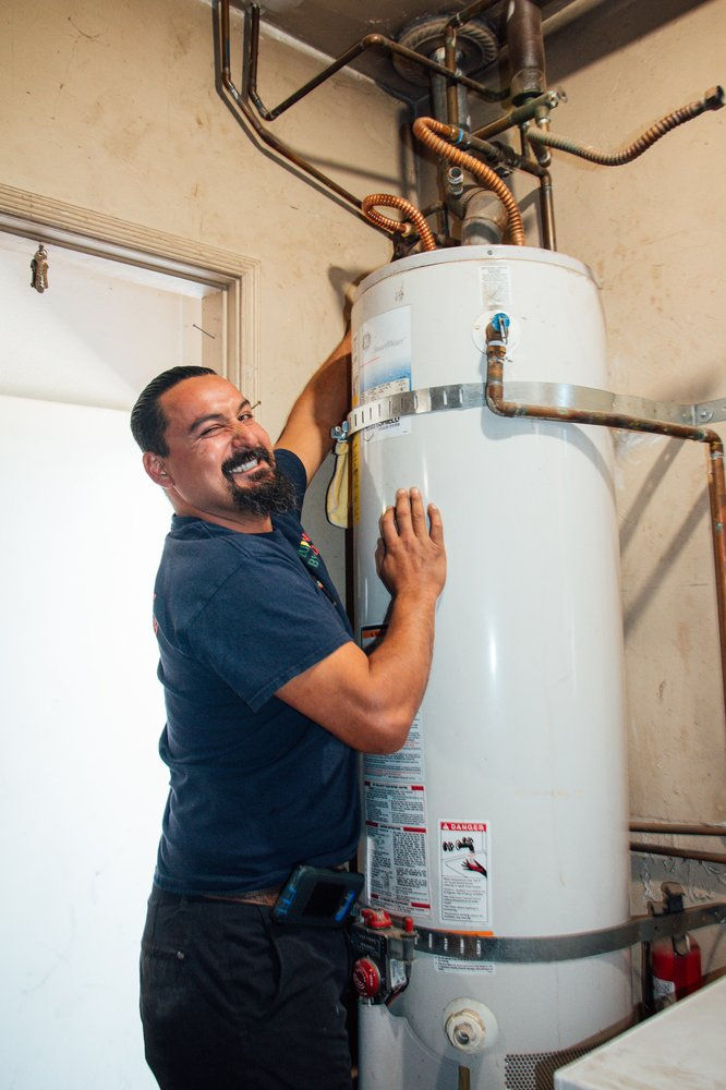 High angle view of a plumber inspecting a water heater