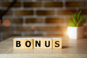 Wooden blocks on wood counter spelling out B-O-N-U-S